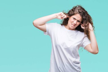 Güzel esmer kıvırcık saçlı Genç kız üzerinde rahat t-shirt giyen arka plan kaplaması kulakları ile parmak ile izole ifade gürültü için yüksek sesle müzik rahatsız. Sağır kavramı.