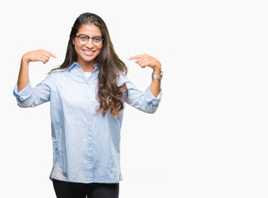 Yüzünde gülümseme ile kendinden emin görünüyorsun, kendini gururlu ve mutlu parmakları ile işaret izole arka plan üzerinde gözlük takan genç güzel Arap kadın.