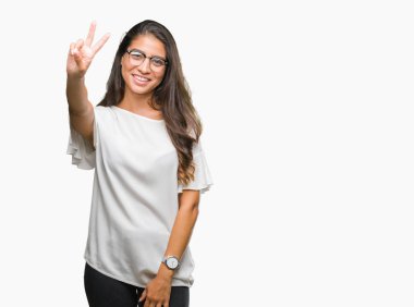 Mutlu yüz zafer işareti yaparken kameraya göz kırpıyor ile gülümseyen izole arka plan üzerinde gözlük takan genç güzel Arap kadın. İki numaralı.