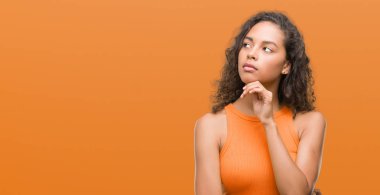 Genç İspanyol kadın ciddi bir yüz düşünme hakkında soru, çok karışık bir fikir