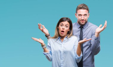 Genç işçiler iş çift izole üzerinde arka plan clueless ve şaşkın bir ifadeyle kollar ve eller kaldırdı. Şüphe kavramı.