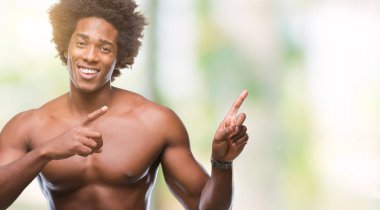 Afro Amerikalı gömleksiz adam çıplak vücut gülümseyen ve iki elleri ve parmakları ile tarafına işaret kamera bakarak izole arka plan üzerinde gösterilen.