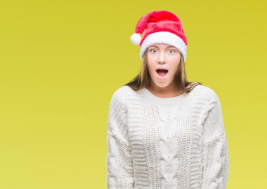 Korkuyor ve şok sürpriz ifade, korku ve heyecan yüz ile izole arka plan üzerinde Noel şapka giyen genç güzel beyaz kadın.