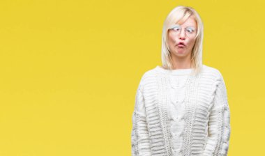 Kış kazak ve gözlük izole arka plan yapma balık yüzüne dudaklı, çılgın ve komik bir jest giyen genç güzel sarışın kadın. Komik ifade.