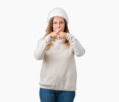 Eksi işareti yapıyor izole arka plan ret ifade geçiş parmakları üzerinde kış kazak ve şapka giyen güzel orta yaş kadın