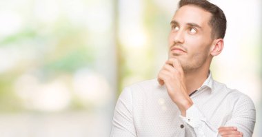 Yakışıklı genç iş adamı ciddi bir yüz düşünme hakkında soru, çok karışık bir fikir