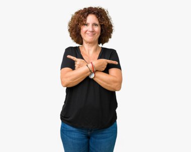 İzole arka plan güzel orta ager üst düzey kadın işaret parmaklarıyla, farklı yönde iki tarafa da aynı fikirde.