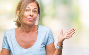 Orta yaş üst düzey İspanyol kadın izole arka plan clueless ve şaşkın bir ifadeyle kollar ve eller kaldırdı. Şüphe kavramı.