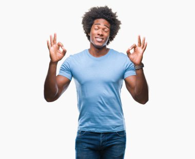 İzole arka plan üzerinde Afro Amerikalı adam rahatla ve gülümseyen gözlerle kapalı parmak jestle meditasyon yapıyor. Yoga kavramı.