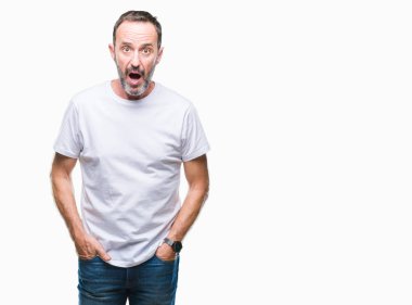 Orta yaş ağarmış komuta sizde korkmuş ve şok sürpriz ifade, korku ve heyecan yüz ile izole arka plan üzerinde beyaz t-shirt giyen.