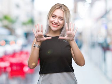 Sarışın genç kadın gösterilen ve parmakları ile işaret izole arka plan üzerinde kendinden emin ve mutlu gülümseyerek süre on numara.