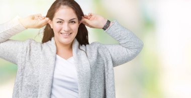 Artı boyutu genç kadın güzel kış ceket üzerinde arka plan gülen çekerek kulakları parmaklar, komik jest ile izole. Seçmelere sorun