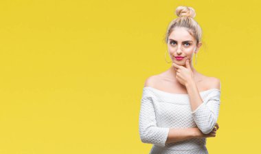 Genç güzel sarışın ve mavi gözlü kadın izole arka plan emin çapraz kollar ve çeneme kaldırdı el ile gülümseme ile kameraya bakıyor. Pozitif düşünce.