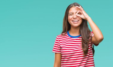 Genç güzel Arap kadın gülümsüyor, parmakları ile mutlu yüz üzerinden seyir göz el ile ok jest yapıyor izole arka plan üzerinde.