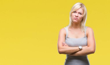 Genç güzel sarışın kadın izole arka plan şüpheci ve çapraz kolları olan yüzündeki gergin, onaylamayan ifade yüzünden. Negatif kişi.