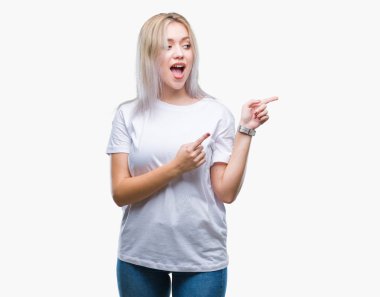 Sarışın genç kadın gülümseyerek ve iki elleri ve parmakları ile tarafına işaret kamera bakarak izole arka plan üzerinde.