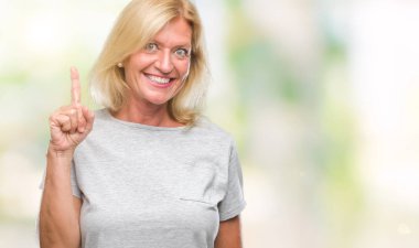 Orta yaş ve kendinden emin ve mutlu gülümseyerek süre parmak numaralı yukarıyı gösteren izole arka plan sarışın kadın.