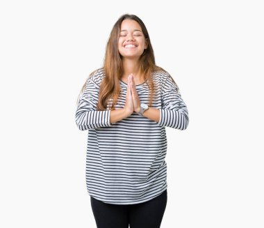 Yalvarıyor ve umut ifade yüzünde çok duygusal ve endişe ile birlikte elleriyle dua izole arka plan üzerinde çizgili süveter giyen genç güzel esmer kadın. Bağışlanmak. Din kavramı.