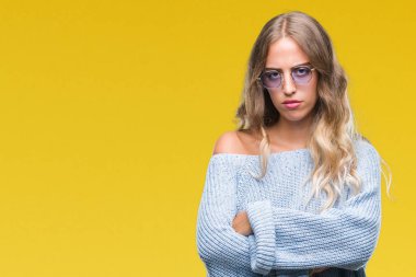 İzole arka plan şüpheci ve sinir, onaylamayan ifade yüz çapraz kolları üzerinde güneş gözlüğü takıyor güzel sarışın genç kadın. Negatif kişi.