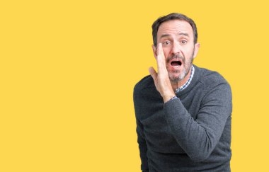 Yakışıklı orta yaş komuta sizde izole arka plan üzerinde bir kazak giyen el gizli söylenti söylüyor Ağızdan kötü amaçlı konuşma konuşma fısıldayan