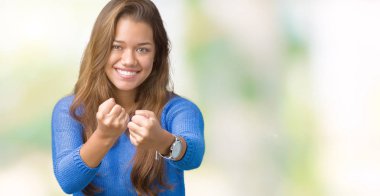 Mavi kazak izole üzerinde giyen genç güzel esmer kadın arka plan yumruk savunma hareketi, kızgın ve üzgün yüz, sorunu korkuyor ile savaşmaya hazır