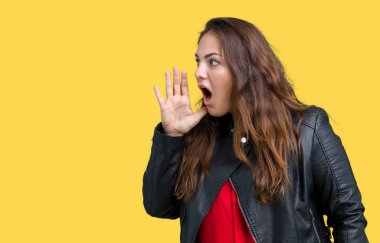 Artı boyutu genç kadın güzel üzerinde bir moda deri ceket giyiyor bağırarak ve ağzı üzerinde el ile yan için çığlık arka plan izole. İletişim kavramı.