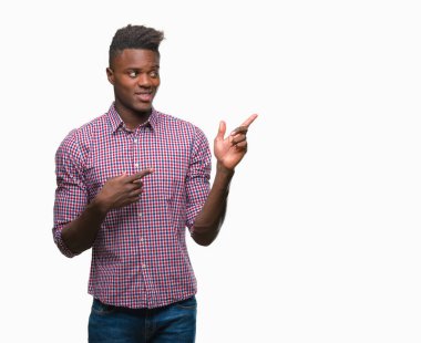 Gülümseyen ve iki elleri ve parmakları ile tarafına işaret kamera bakarak izole arka plan üzerinde genç Afro-Amerikan adam.