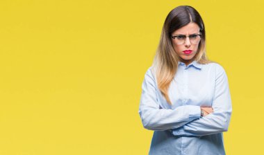 İzole arka plan şüpheci ve çapraz kolları olan yüzündeki gergin, onaylamayan ifade gözlüklü genç güzel iş kadını. Negatif kişi.