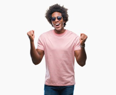 İzole arka plan kutlama üzerinde güneş gözlüğü takıyor Afro Amerikalı adam şaşırttı ve başarı için kaldırdı kollarını açarak hayret ve gözleri açık. Kazanan kavramı.
