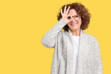 Mutlu yüz parmaklarıyla bakarak göz güzel orta ager kadın kıdemli giyen ceket ve gözlük el gülümseyen, ok jest yapıyor izole arka plan üzerinde.