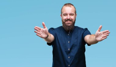 Sarılmak için kollarını açarak gülümseyerek kameraya bakarak izole arka plan Genç beyaz hipster adam. Neşeli ifade kucaklayan mutluluk.