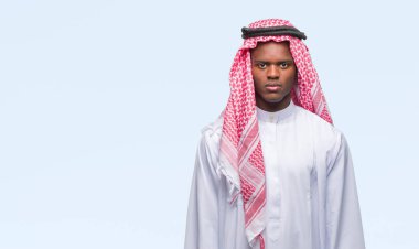 Geleneksel keffiyeh yüzünde ciddi bir ifade ile izole arka plan üzerinde giyen genç Arapça Afrika adam. Basit ve doğal kameraya bakıyor.