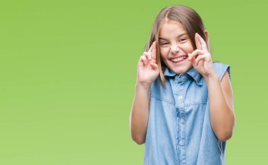 Genç güzel kız umut ve gözleri kapalı geçiş parmaklarıyla gülümseyen izole arka plan yüzünden. Şans ve batıl kavramı.