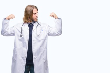Genç yakışıklı adam uzun saçlı gururlu gülümseyen kol kasları gösterilen izole arka plan üzerinde doktor. Fitness kavramı.