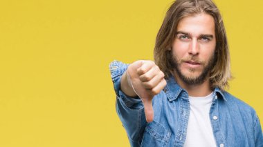 Mutsuz ve kızgın ret gösterilen ve başparmak aşağı hareketi ile negatif seyir izole arka plan üzerinde uzun saçlı Genç yakışıklı adam. Kötü ifade.