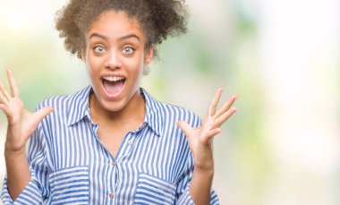 Genç afro Amerikan kadın deli kutluyor ve silah ile başarı için heyecanlı çığlık kaldırdı ve açık gözleri hayret izole arka plan yüzünden. Kazanan kavramı