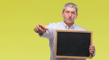 Yakışıklı kıdemli öğretmen adam holding tahta kamera ve size parmak ile işaret izole arka plan üzerinde el işareti, pozitif ve kendinden emin bir jest ön