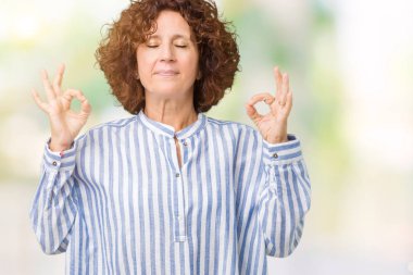 İzole arka plan üzerinde Donanma forması giyen güzel orta ager üst düzey kadın dinlenmek ve gülümseyen gözlerle kapalı parmak jestle meditasyon yapıyor. Yoga kavramı.