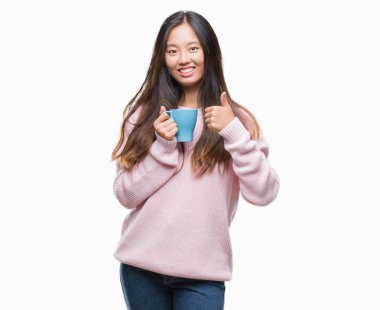 Ok işareti, başparmak ile parmak, mükemmel işareti yapıyor kocaman bir gülümseme ile izole arka plan üzerinde mutlu kahve içme Genç Asyalı kadın