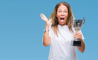 Orta yaş İspanyol kazanan kadın Ödülü holding trophy üzerinde kutluyor büyük gülümseme ile çığlık zaferini kutluyor ve ellerini kaldırdı arka plan çok mutlu ve heyecanlı, kazanan ifade izole