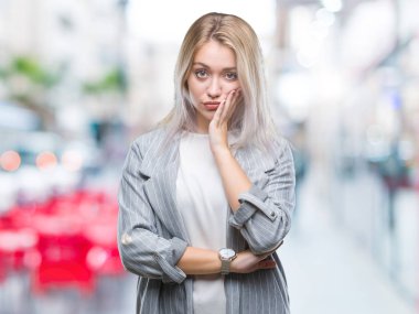 Düşünme izole arka plan bakmaktan ceket giyen genç sarışın iş kadın yorgun ve sıkılmış çapraz silah depresyon sorunları ile.