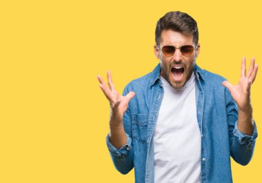 Yakışıklı delikanlı deli ve silah ile başarı için deli kutluyor izole arka plan üzerinde güneş gözlüğü takıyor kaldırdı ve heyecanlı çığlık gözler kapalı. Kazanan kavramı
