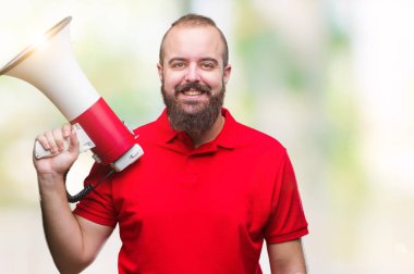 Beyaz delikanlı megafon ile izole arka plan üzerinde duran ve diş gösterilen kendine güvenen bir gülümsemeyle gülümseyerek mutlu bir yüz ile bağırıyor