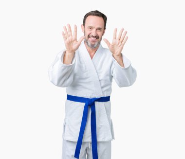 Yakışıklı orta yaş komuta sizde kimono üniforması üzerinde gösterilen arka plan izole ve parmakları ile işaret kendinden emin ve mutlu gülümseyerek süre on numara.