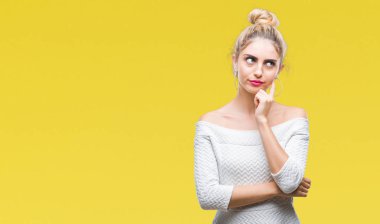 Kadın el ile arka plan üzerinde izole genç güzel sarışın ve mavi gözleri soru, dalgın ifade düşünmeye çene. Düşünceli yüzüyle gülümsüyor. Şüphe kavramı.