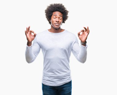 İzole arka plan üzerinde Afro Amerikalı adam rahatla ve gülümseyen gözlerle kapalı parmak jestle meditasyon yapıyor. Yoga kavramı.