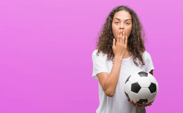 Junge Hispanische Frau Hält Fußballball Bedeckt Mund Mit Hand Schockiert — Stockfoto
