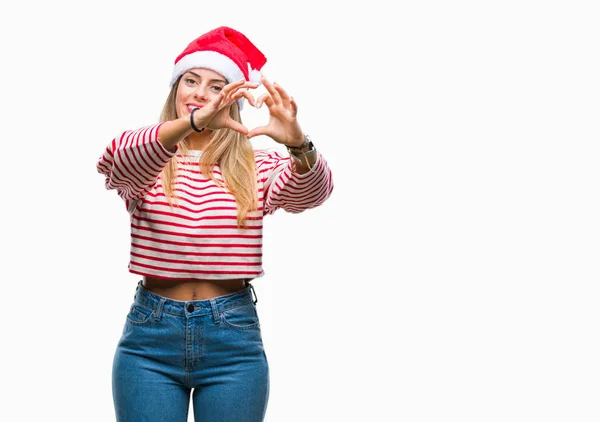 若い美しい女性のハートマークと手で形を示す愛の笑みを浮かべて隔離された背景にクリスマス帽子をかぶっています ロマンチックな概念 — ストック写真