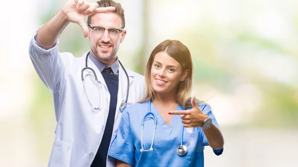 Casal Jovem Médico Cirurgião Sobre Fundo Isolado Sorrindo Fazendo Quadro — Fotografia de Stock