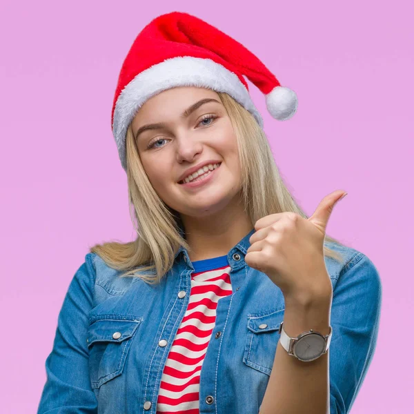 若い白人女性のハッピー サムズアップ手でジェスチャーをして孤立した背景にクリスマス帽子をかぶっています 成功を示すと カメラを見て式を承認します — ストック写真